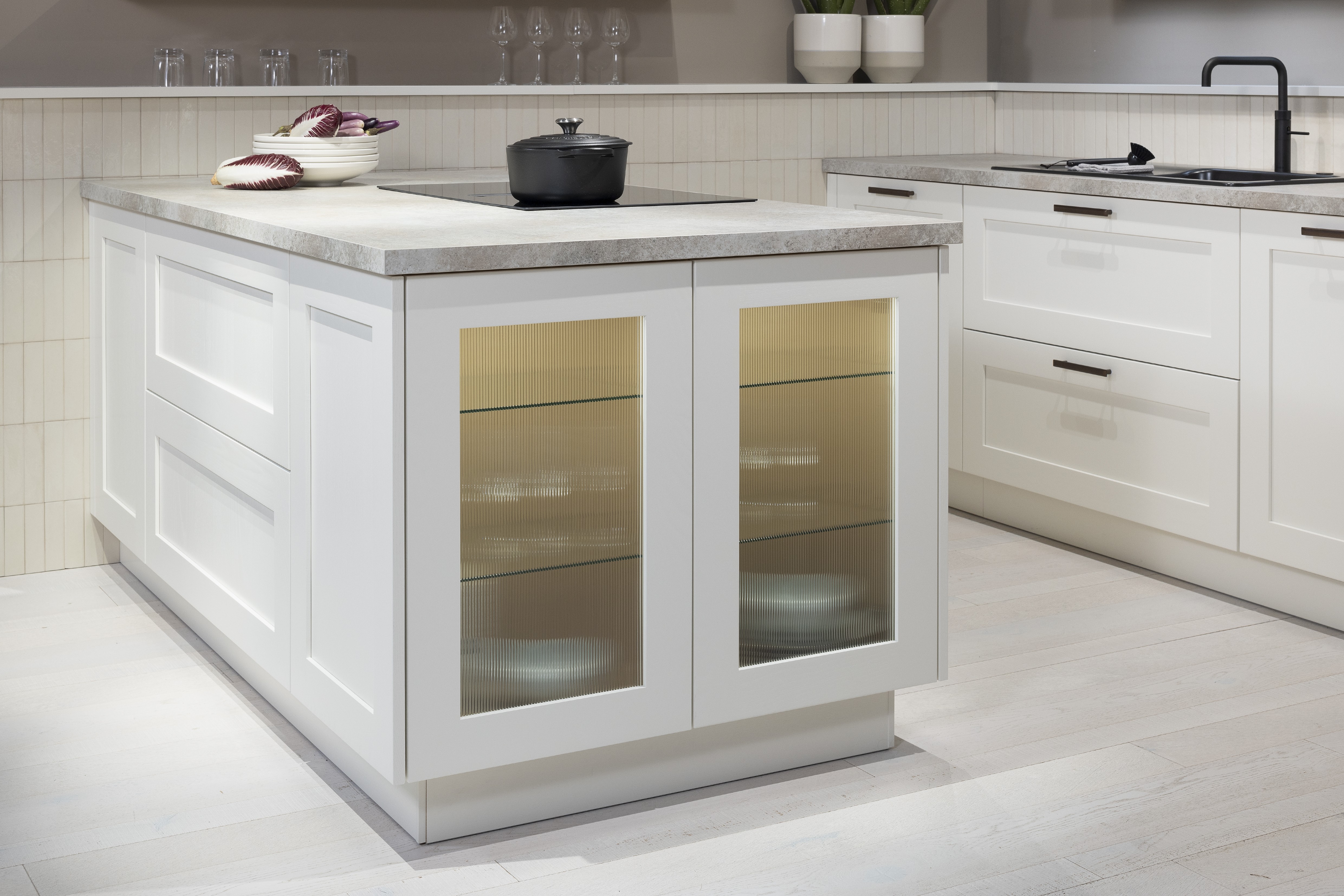 APL: 15 Kalkstein Repro 25 mm Front: AV 6055 Weiß Echtholz lackiert,  Front 2: AV 6082 Wildeiche-natur Korpus: 2085 Designkorpus Feineiche-natur Griff: 515 Metall Bronze-dunkel Geräte: Bosch  Armatur: Quooker Spüle: Systemceram   Features: Landhausküche modern, Echtholz RAL und NCS lackierbar, Riffelglasvitrine, Beleuchtung, schwebender Block, Echtholzfurnier lackiert kombiniert mit Echtholzfurnier, Fliesen, Korpus Echtholz Feineiche Natur, Griffe in Bronze. 