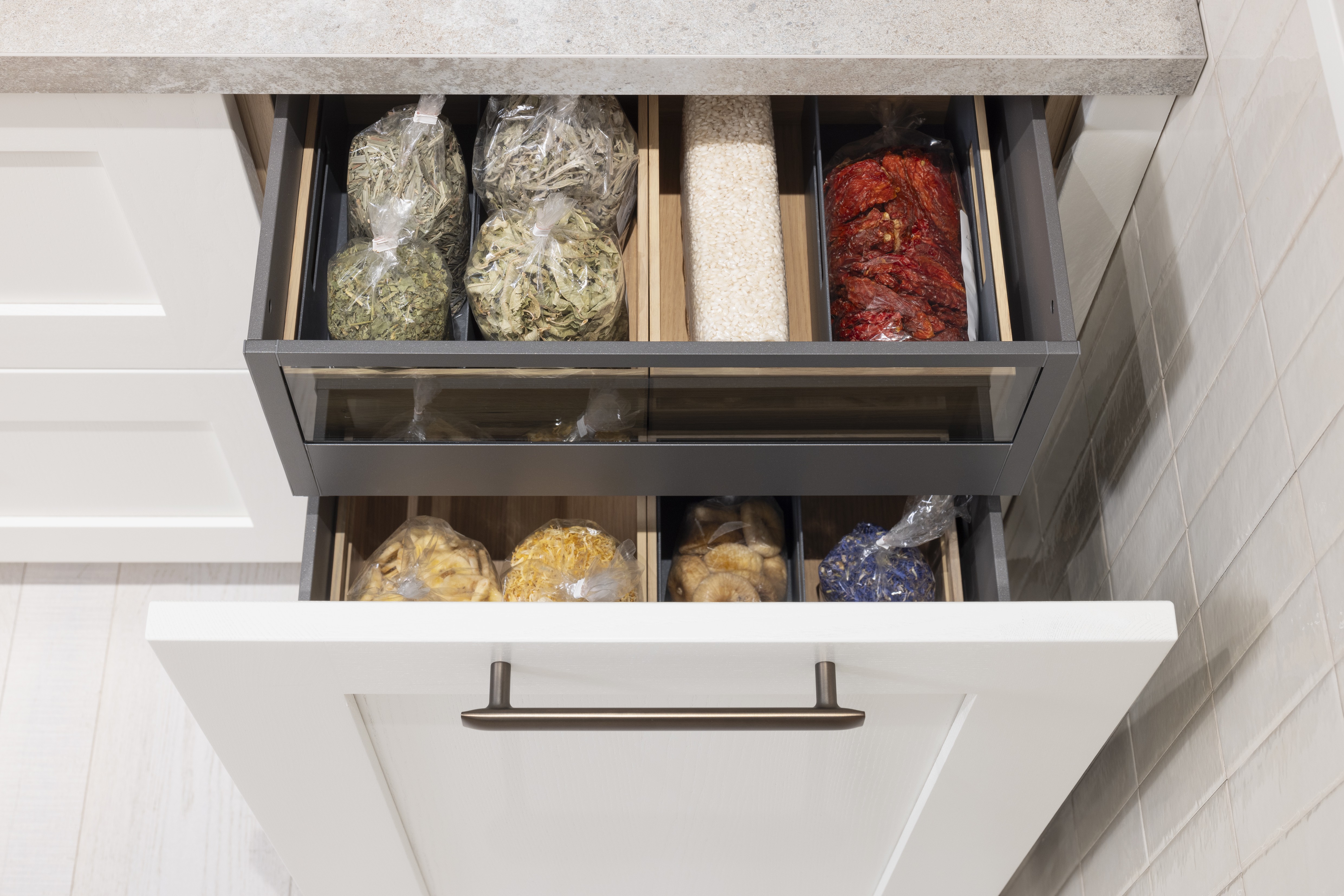 APL: 15 Kalkstein Repro 25 mm Front: AV 6055 Weiß Echtholz lackiert,  Front 2: AV 6082 Wildeiche-natur Korpus: 2085 Designkorpus Feineiche-natur Griff: 515 Metall Bronze-dunkel Geräte: Bosch  Armatur: Quooker Spüle: Systemceram   Features: Landhausküche modern, Echtholz RAL und NCS lackierbar, Riffelglasvitrine, Beleuchtung, schwebender Block, Echtholzfurnier lackiert kombiniert mit Echtholzfurnier, Fliesen, Korpus Echtholz Feineiche Natur, Griffe in Bronze. 